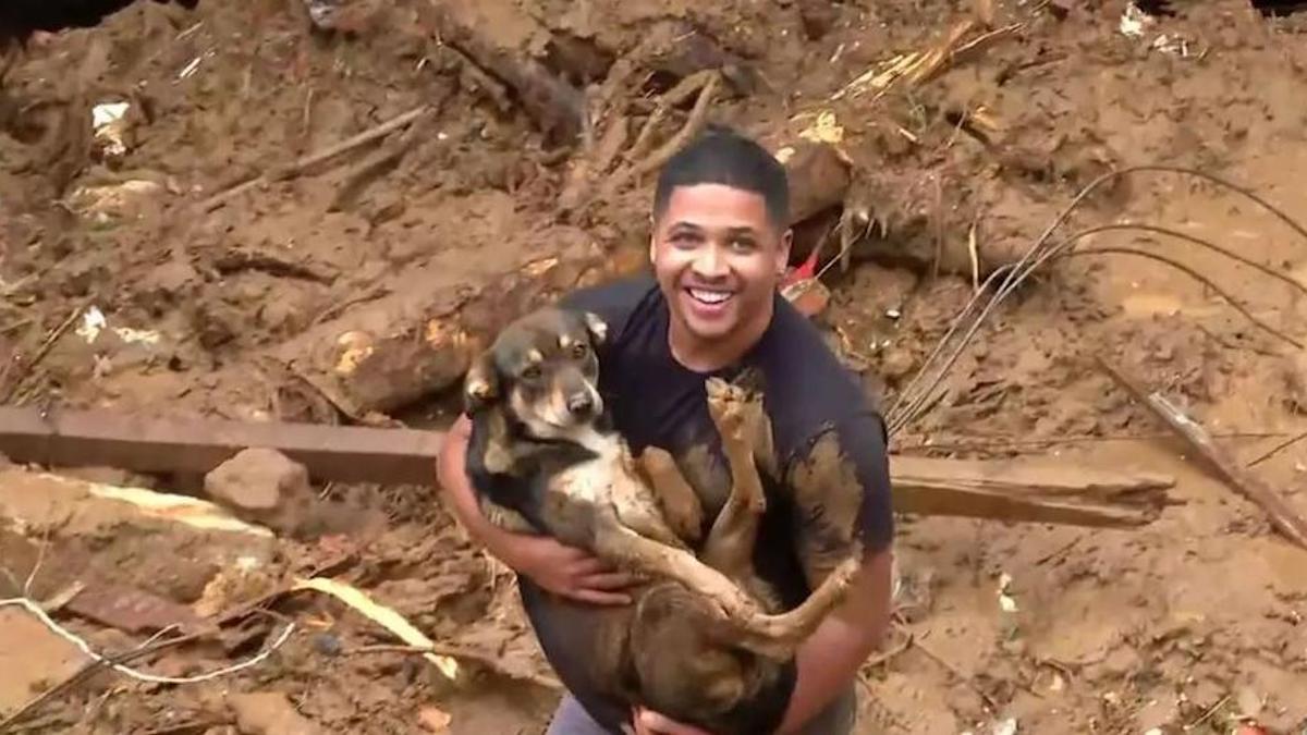 Un jeune homme cherchant sa famille dans la boue retrouve son chien